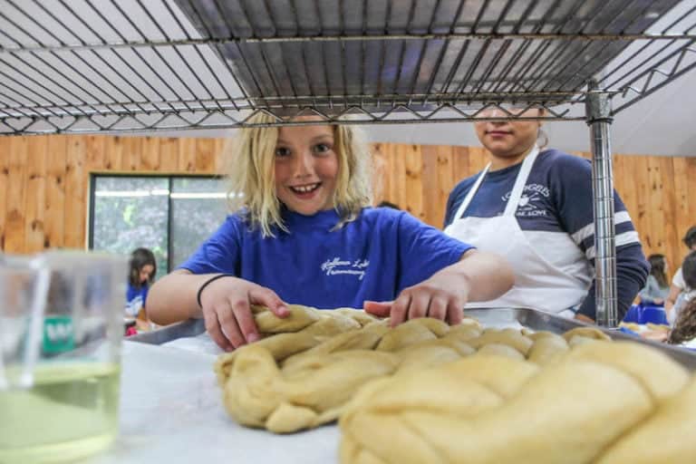 Kids making homemade bread at Eden Village Camp, a sustainable Jewish summer camp focused on community, environmental awareness, and hands-on activities in a rural setting.