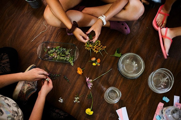 Flowers workshop at Eden Village Camp, children creating floral arrangements, outdoor summer camp activities, eco-friendly environment, nature-based education, sustainable living activities.