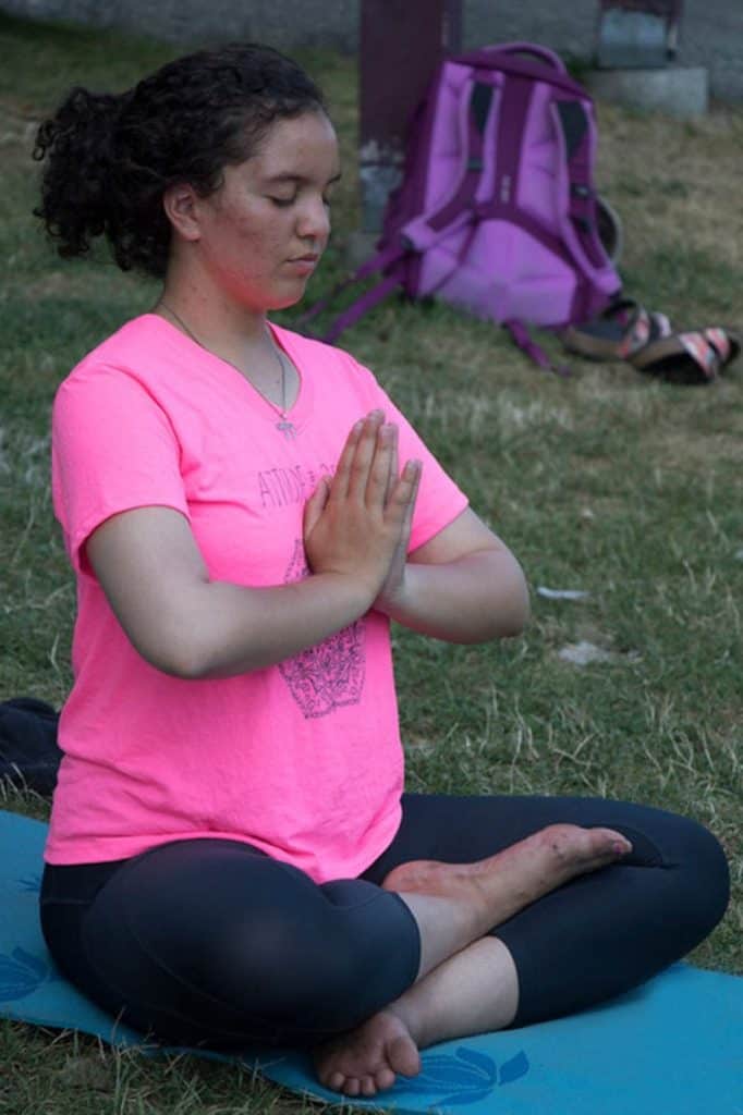 Girl practicing yoga or meditation in nature at Eden Village Camp, promoting mindfulness and outdoor activities for children and teens.