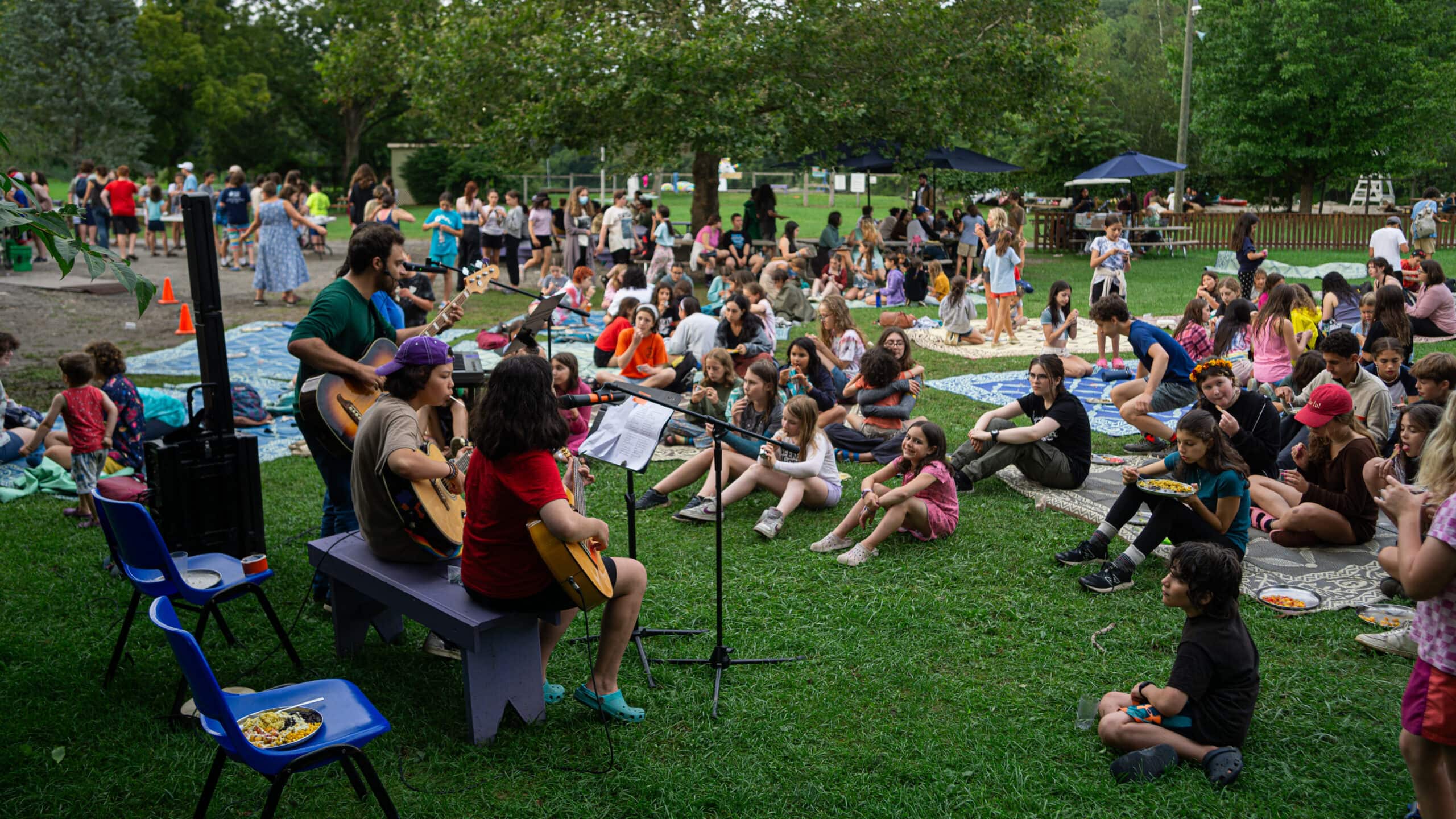 group having dinner while performers sing and play guitar