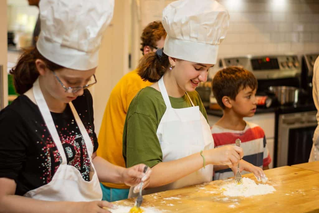Freshly baked with kids and counselors at Eden Village Camp, highlighting educational cooking activities and community to foster environmental awareness and youth engagement.