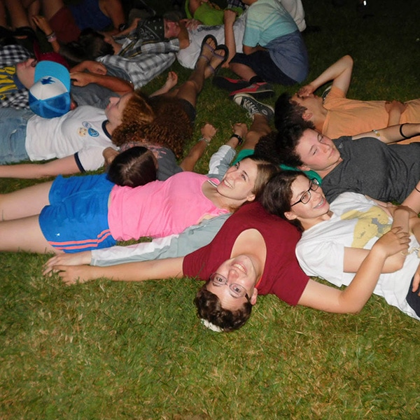 group of kids relaxing together on grass in evening