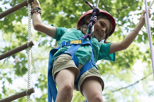 camper with harness on obstacle course
